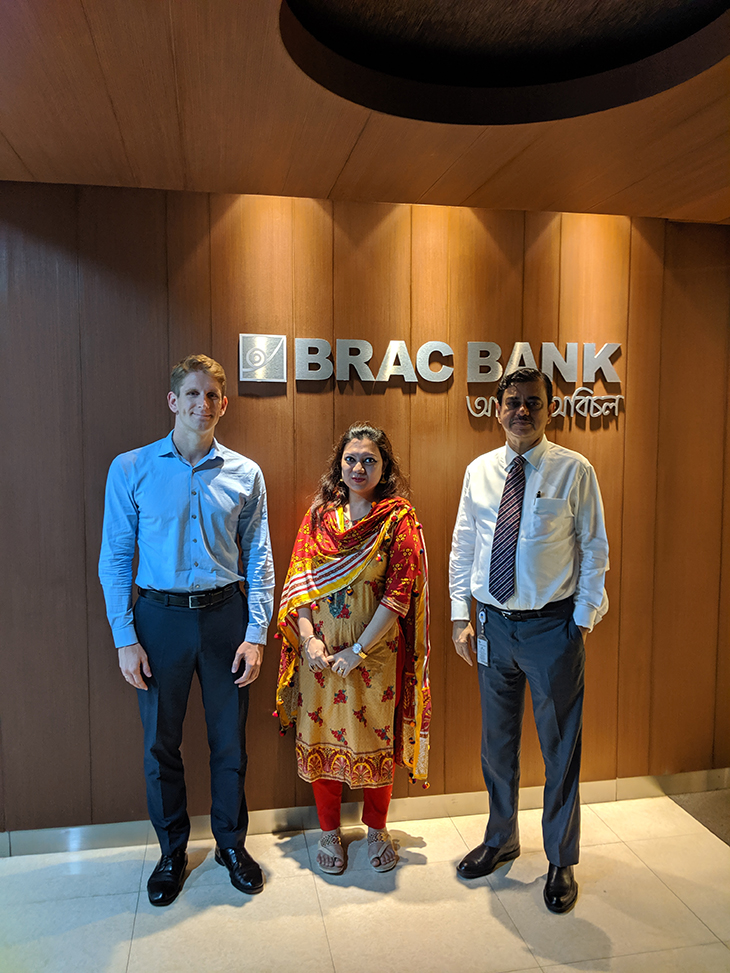 Three people standing in front of a Bangladesh-bank-frontier